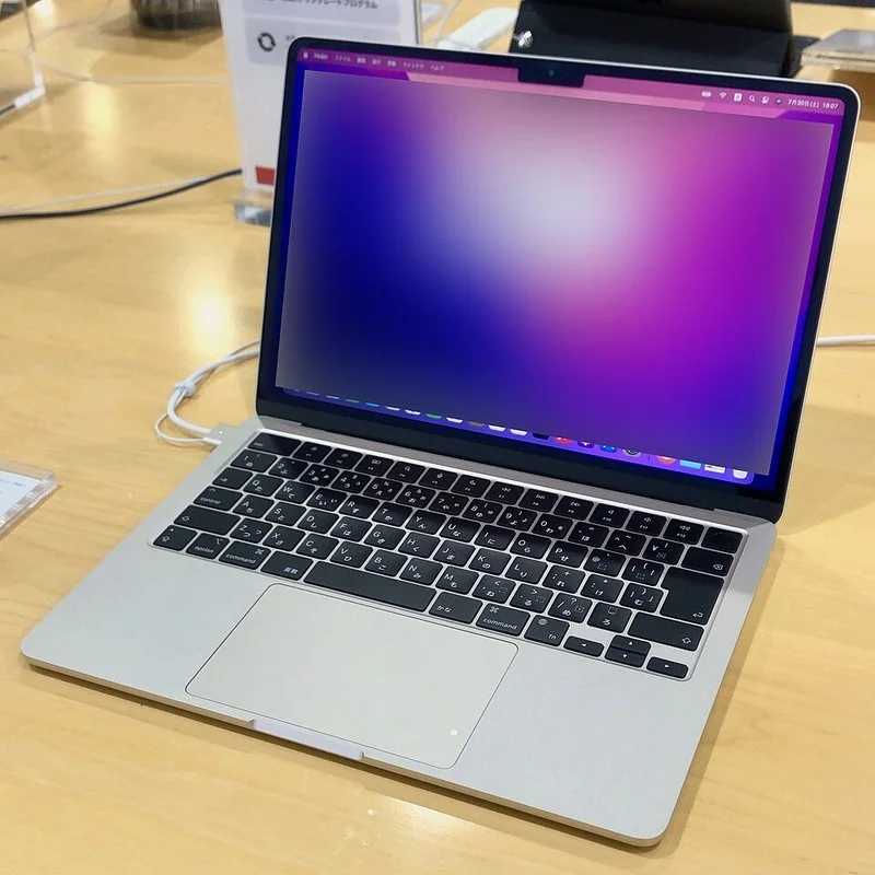 que ordenador portátil me recomiendan, MacBook Air plateado abierto con pantalla encendida en mesa de exposición
