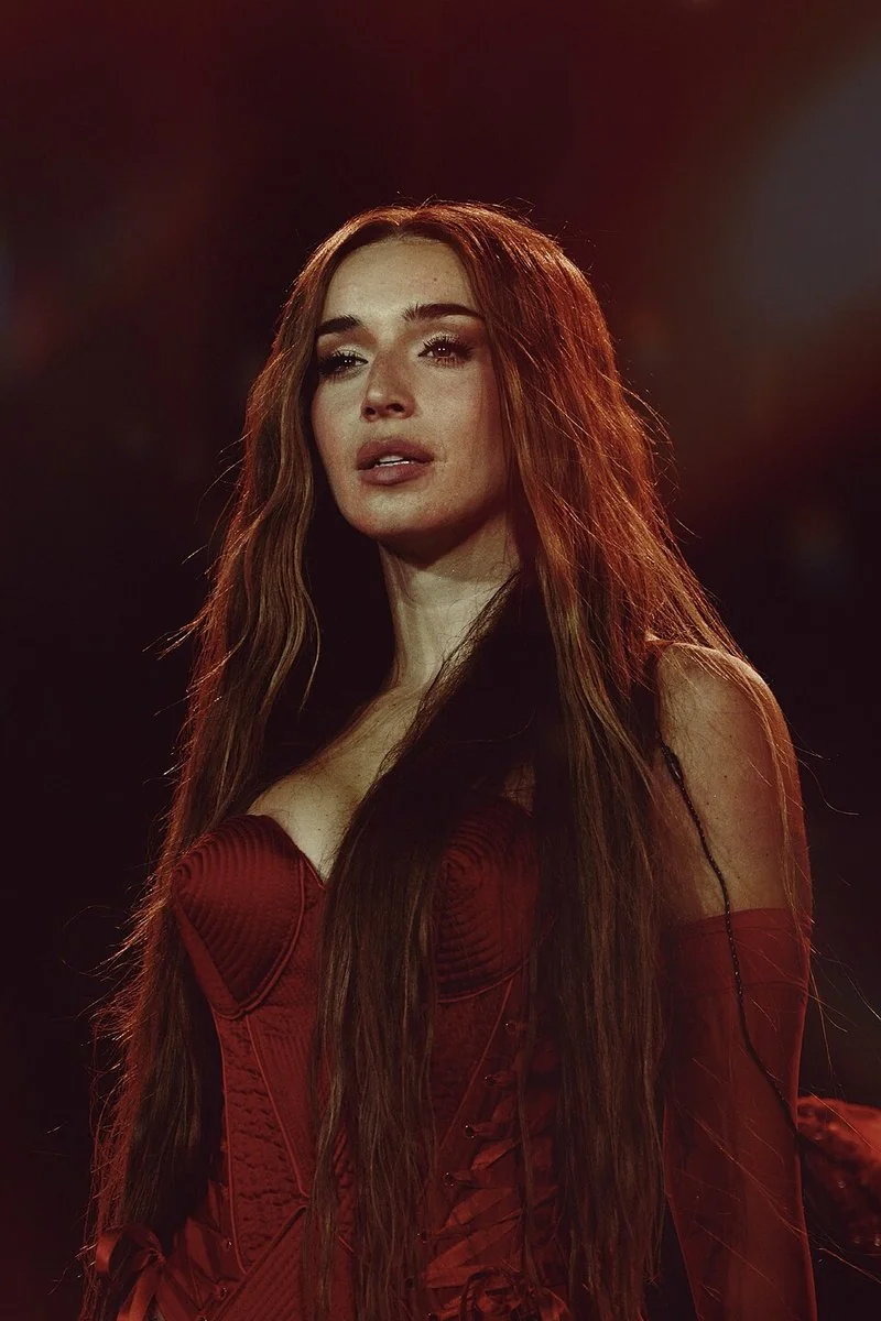 Lola Índigo en concierto con vestido rojo y cabello largo; no es IlloJuan.