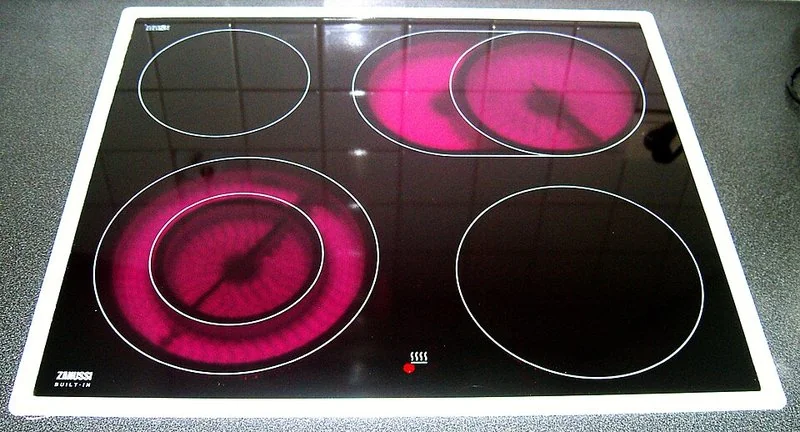 que producto es mejor para limpiar la vitroceramica, Placa vitrocerámica con dos zonas de cocción encendidas en rojo, de cuatro fuegos