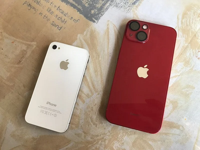 que significa iphone outlet, Vistas traseras de un iPhone 13 rojo y un iPhone 4s blanco, modelos de outlet